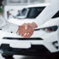 close-up-sales-manager-black-suit-selling-car-customer